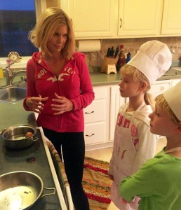 Sarah Hotchkiss with her kids teaching them how to make eggs.